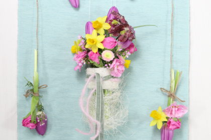Hängegesteck mit Luffa Gurke und Frühlingsblumen in Reagenzgläsern